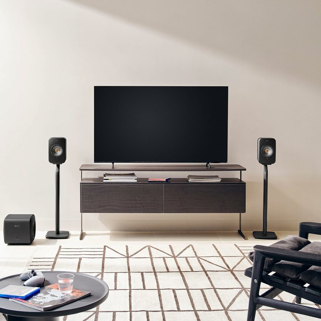 Caixa de som KEF LSX II Preto carbono em uma sala entre uma televisão